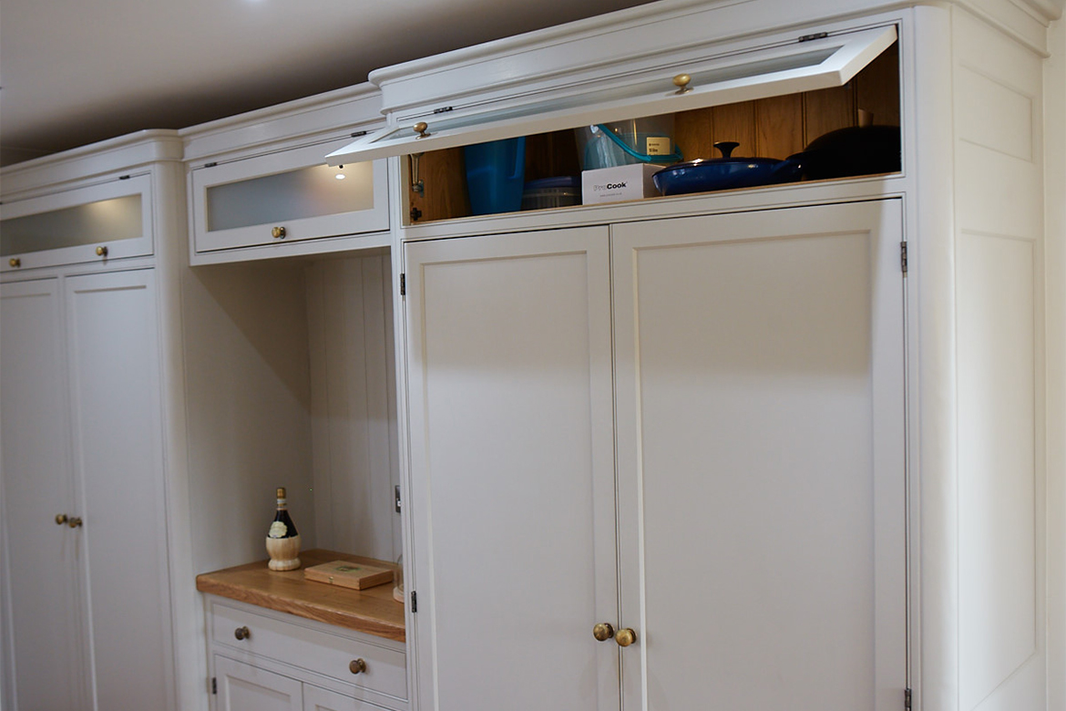 Tall bespoke painted kitchen cabinet with top glazed door open