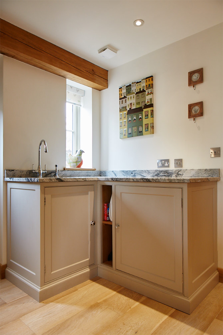 Bespoke painted cabinets allow a small utility 'l' section with inset sink and granite worktops
