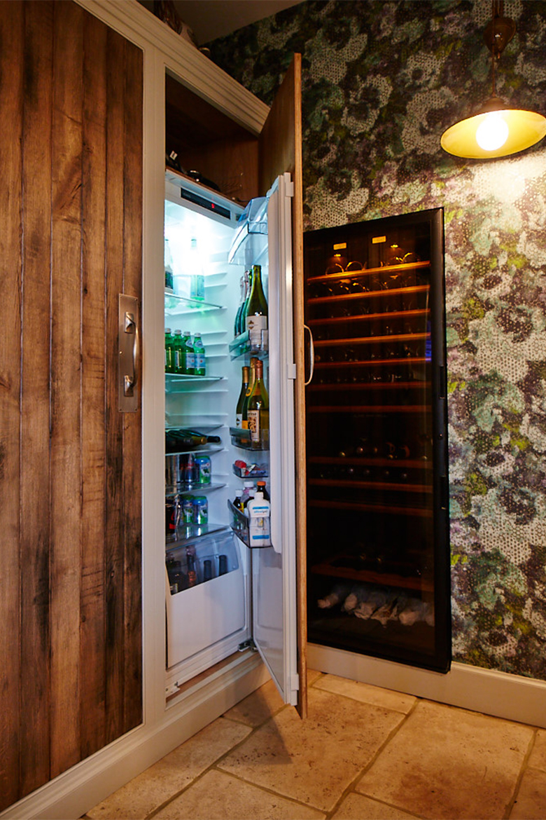 Tall bespoke integrated kitchen beer fridge with solid oak reclaimed rustic door and pewter pull handles