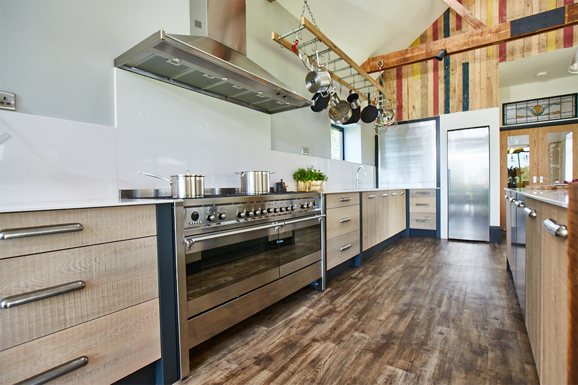 Stainless steel fisher paykel range cooker in between engineered slab oak rustic bespoke kitchen drawers