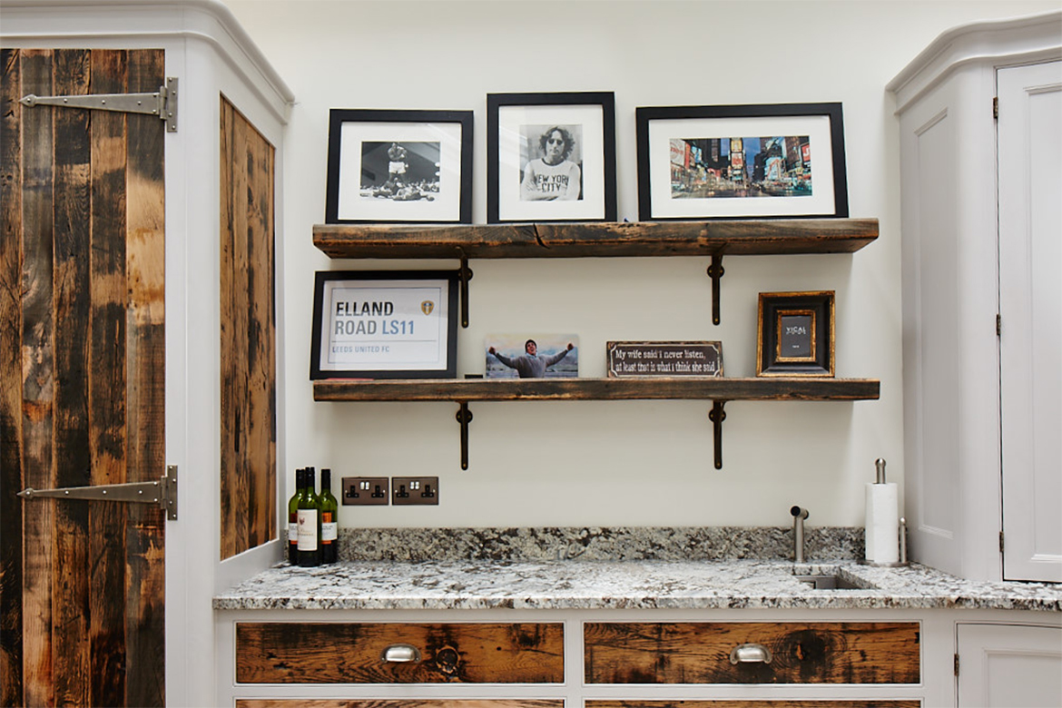 Thick oak reclaimed wood shelves on cast iron brackets with display of photo frames