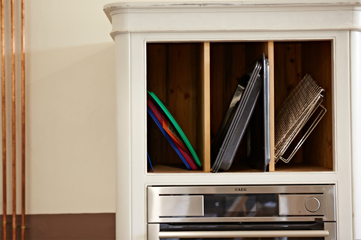 Solid pine divides chopping boards in tall bespoke kitchen units