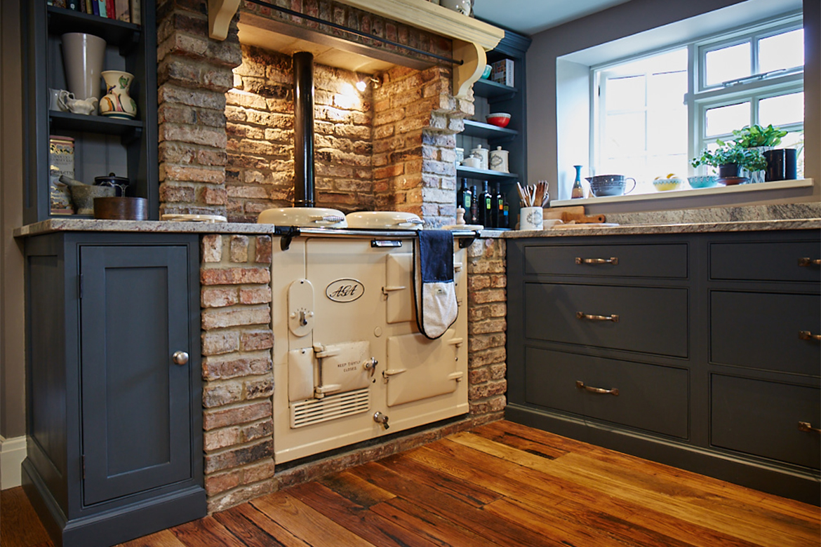 Original Cream Aga sits in chimney breast with bespoke painted kitchen cabinets