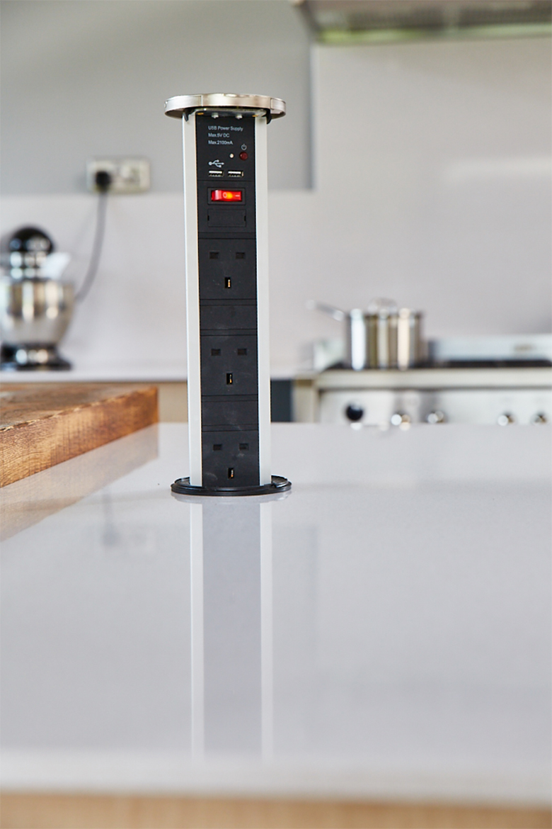 Integrated hafele pop up plug with chrome detail in kitchen island with dekton worktop