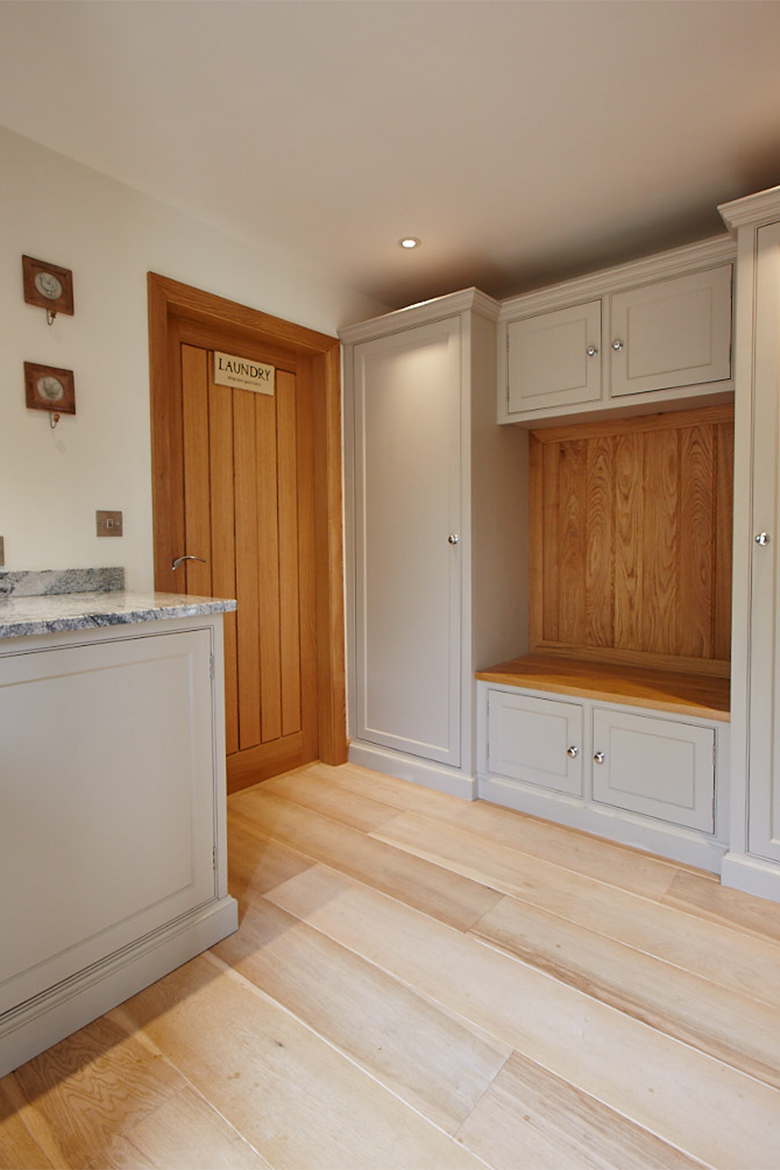 Solid oak laundry door with bespoke painted cabinets and boot cupboard