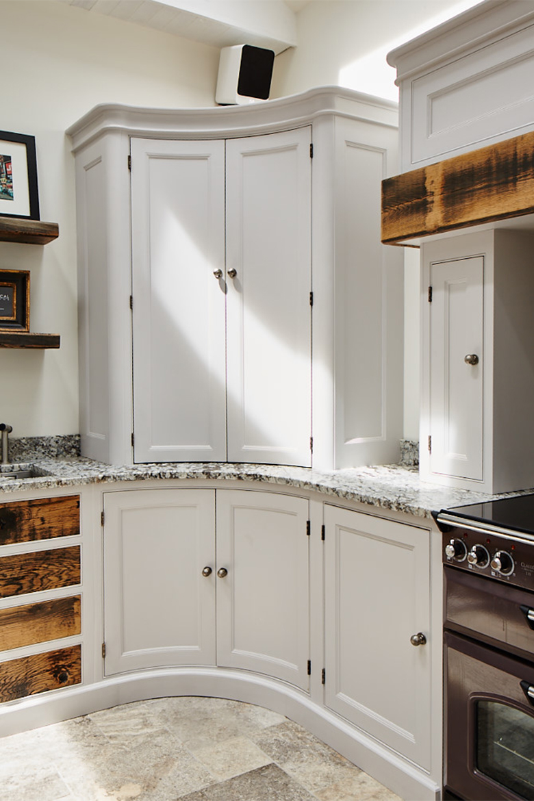 Curved kitchen cabinets with granite worktop and pewter handles