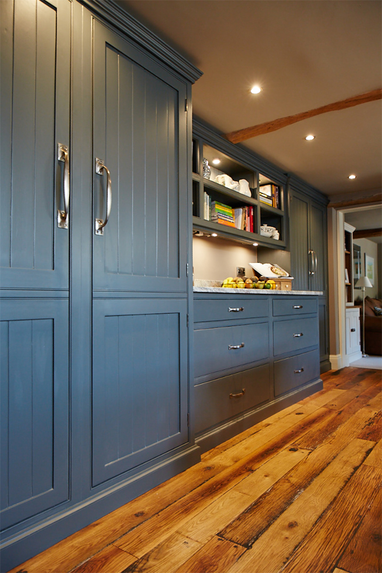 Tall bespoke kitchen larder painted deep blue with tongue and groove door panels