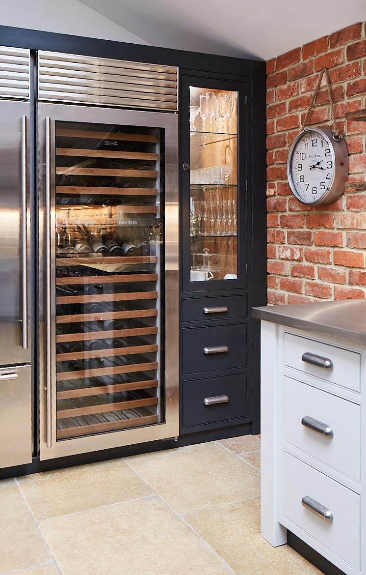 Full height Wolf stainless steel wine fridge next to a bespoke glazed cabinet