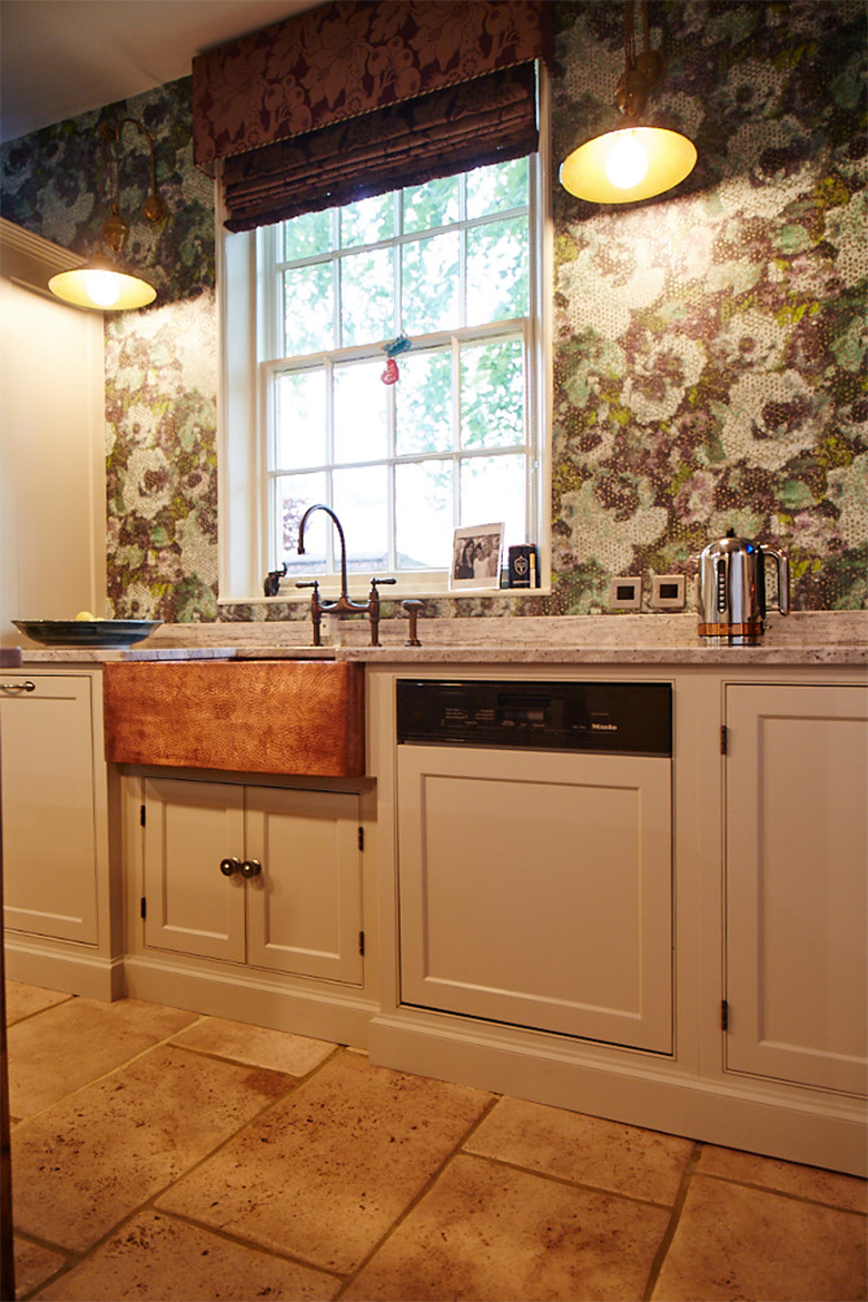 Bespoke painted kitchen run in Little Greene with integrated Miele dishwasher and beaten copper belfast sink with colourful green wallpaper