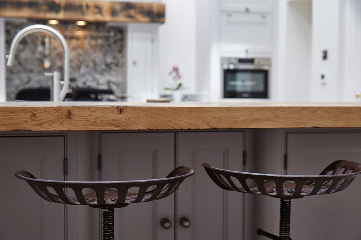 Cast iron stools under reclaimed oak breakfast bar