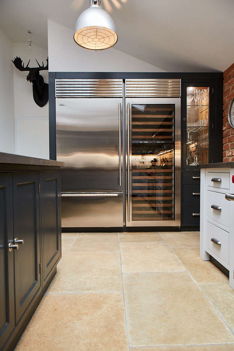 Large full height stainless steel Wolf wine fridge and fridge freezer next to bespoke painted cabinets