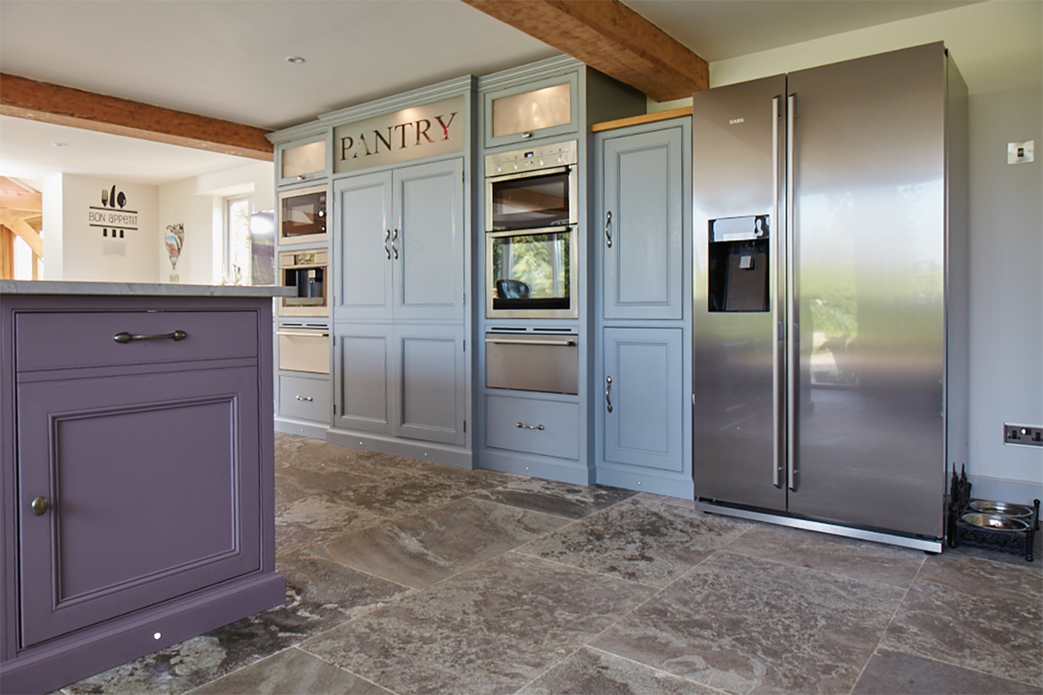 American stainless steel fridge sits beside tall painted integrated kitchen units