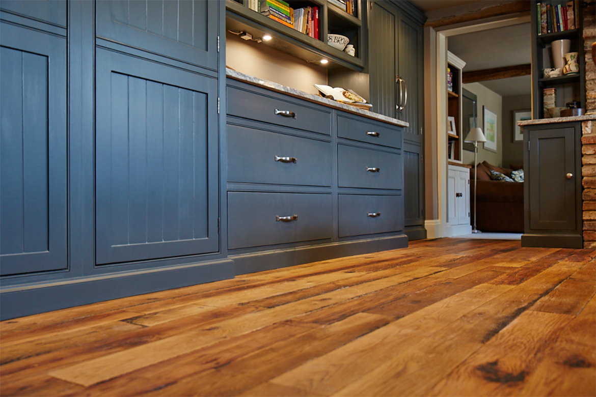 Bespoke painted dark blue kitchen units on engineered oak wood floor