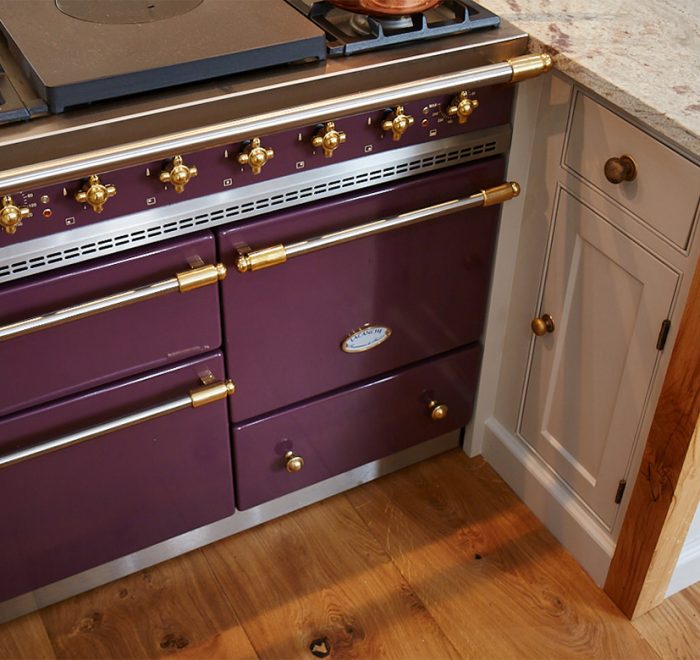 Classic plum macon lacanche with brass trim set in between painted bespoke cabinets with oak posts