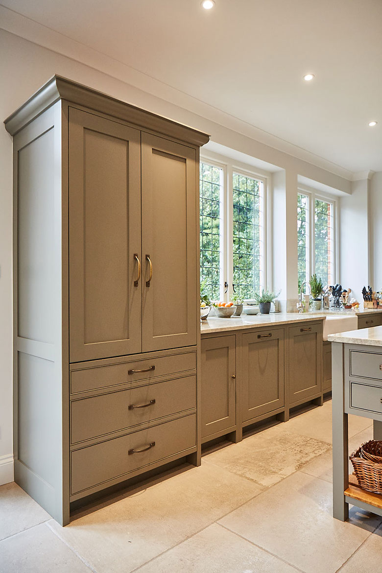 Tall traditional larder unit with large cornice next to crittall windows