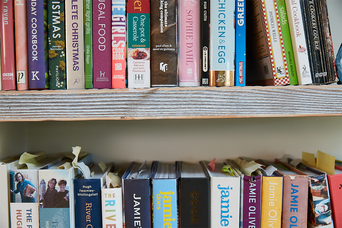 Row of books on engineered pine floating book shelf in whitewash finish