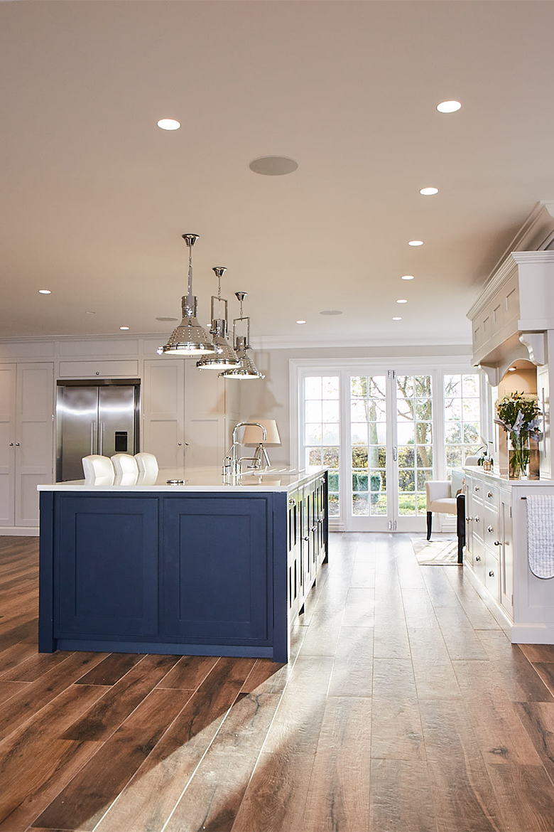 Chrome pendant lights over shaker blue kitchen island with Centaurus grey worktop