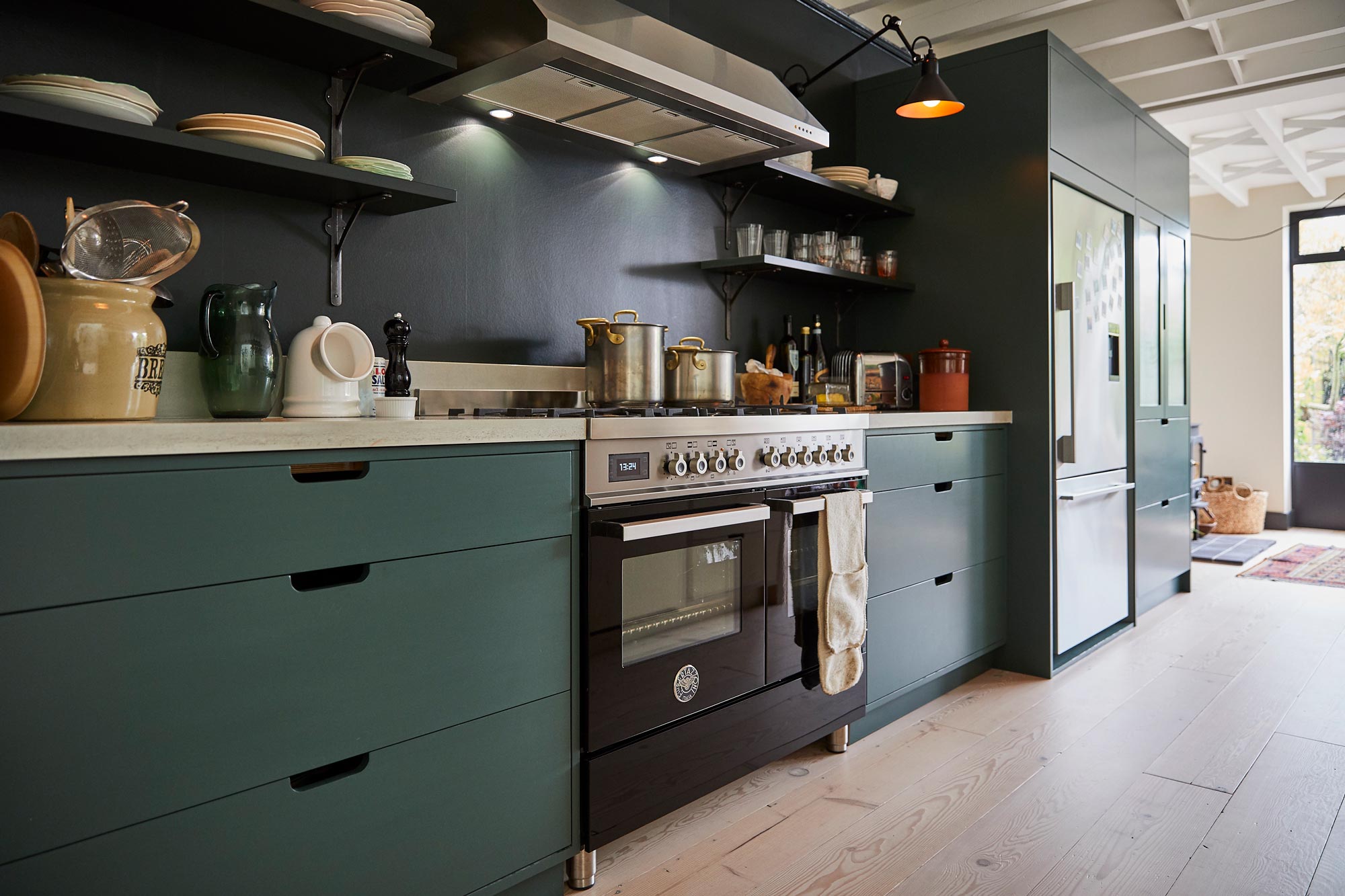 Range cooker next to painted birch plywood kitchen unit and concrete worktop