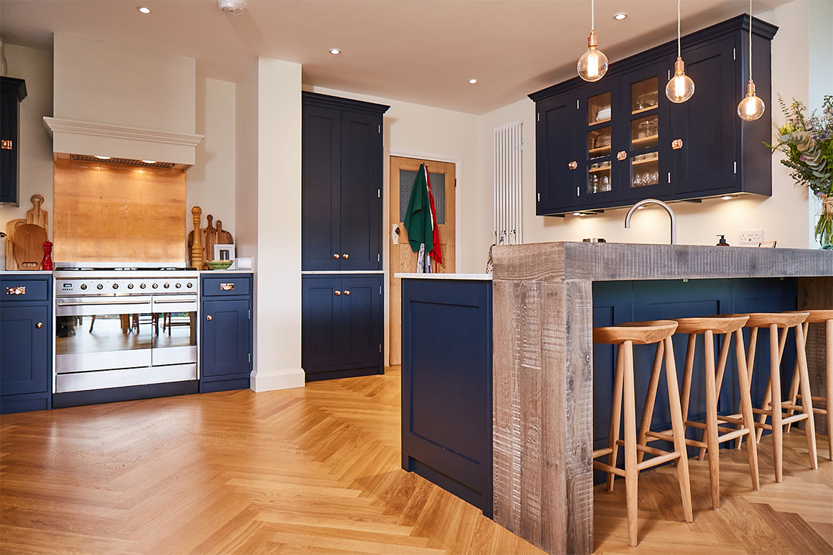 Hand aged chunky oak breakfast bar with dark blue painted cabinets under and clean oak bar stools