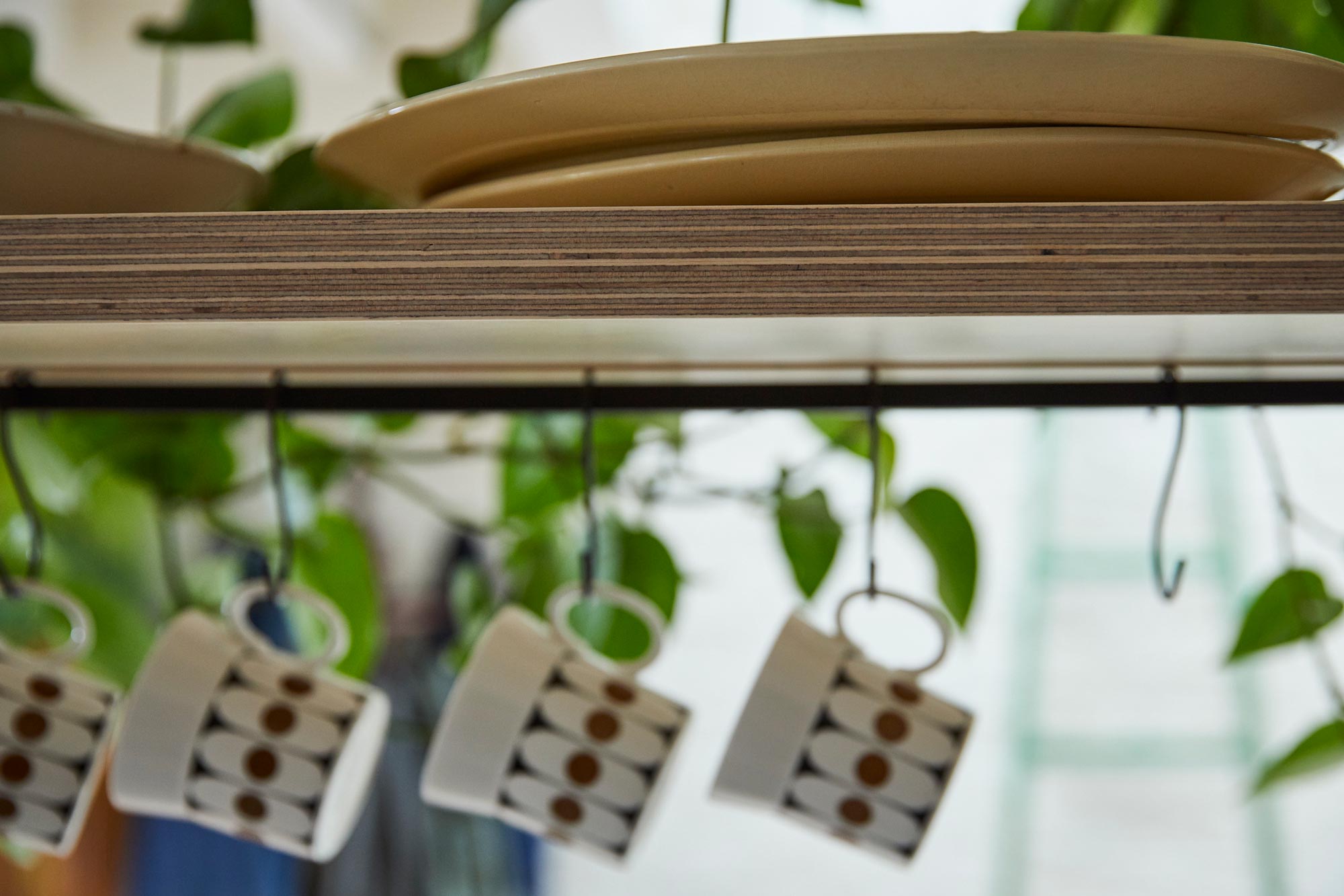 Ceramic mugs hanging from metal rail