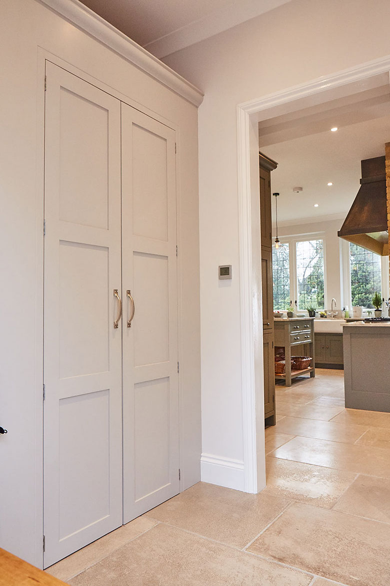Tall Light painted cabinets with traditional finish and Croft brass pull handles