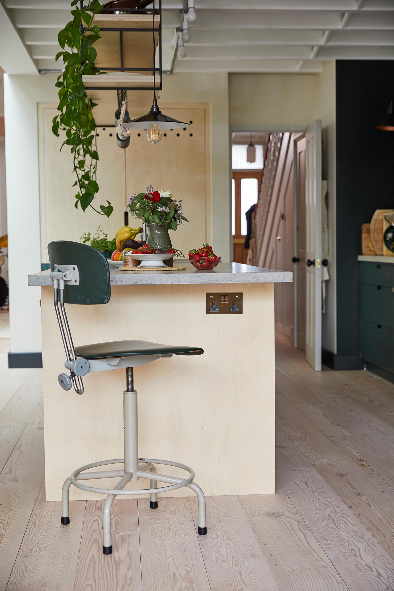 Industrial swivel green barstool under concrete breakfast bar