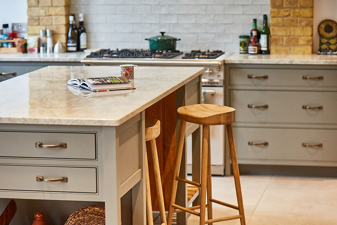 Cook book rests on granite worktop with oak bar stool pulled out