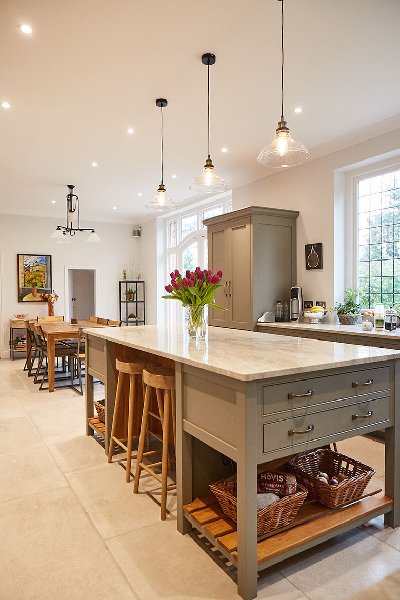 Bespoke kitchen island painted grey moss with granite worktop and glass pendant lights above