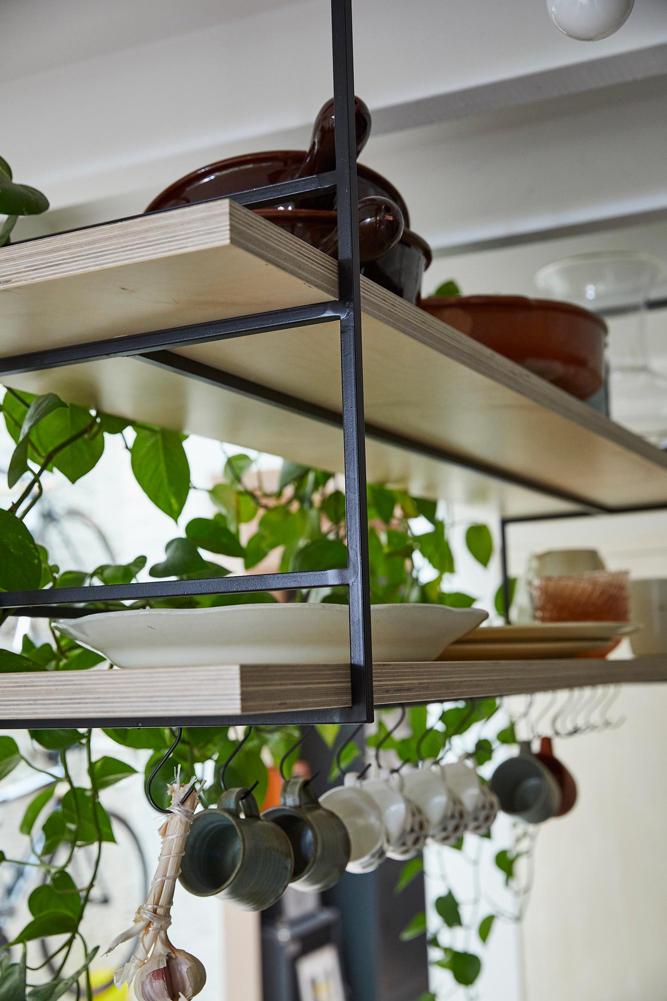 Open shelves made from birch plywood with plants and plates stacked on
