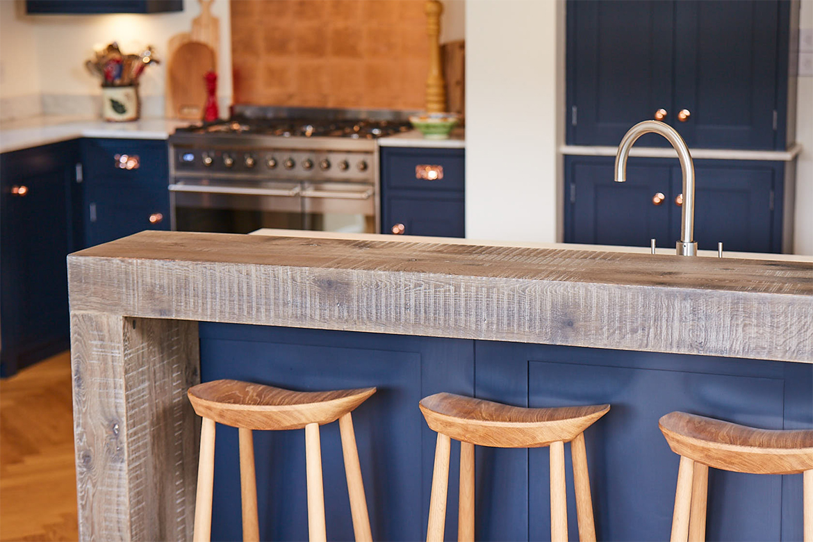 Engineered oak breakfast bar with blue painted back panel and oak stools