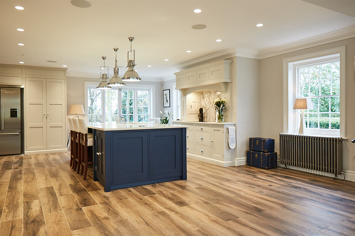 Painted shaker blue kitchen island with large chrome pendant lights above