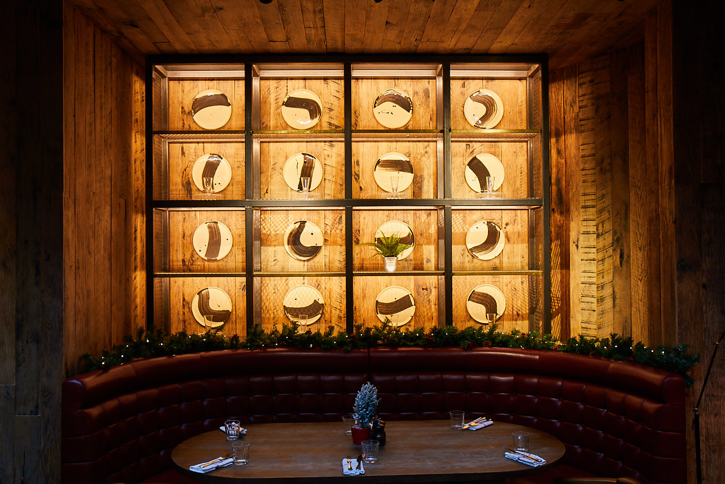 Eatery booth with industrial shelves and round mirrors behind