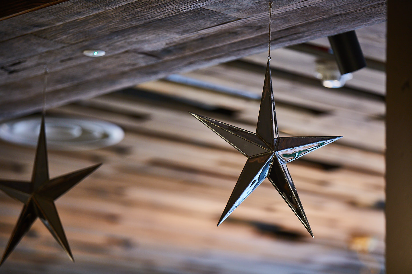 Metal star hangs from wood cladded ceiling