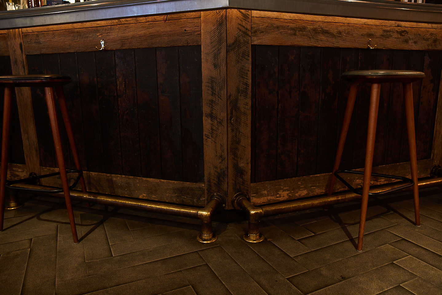 Rustic bar with oak stools and brass foot rail