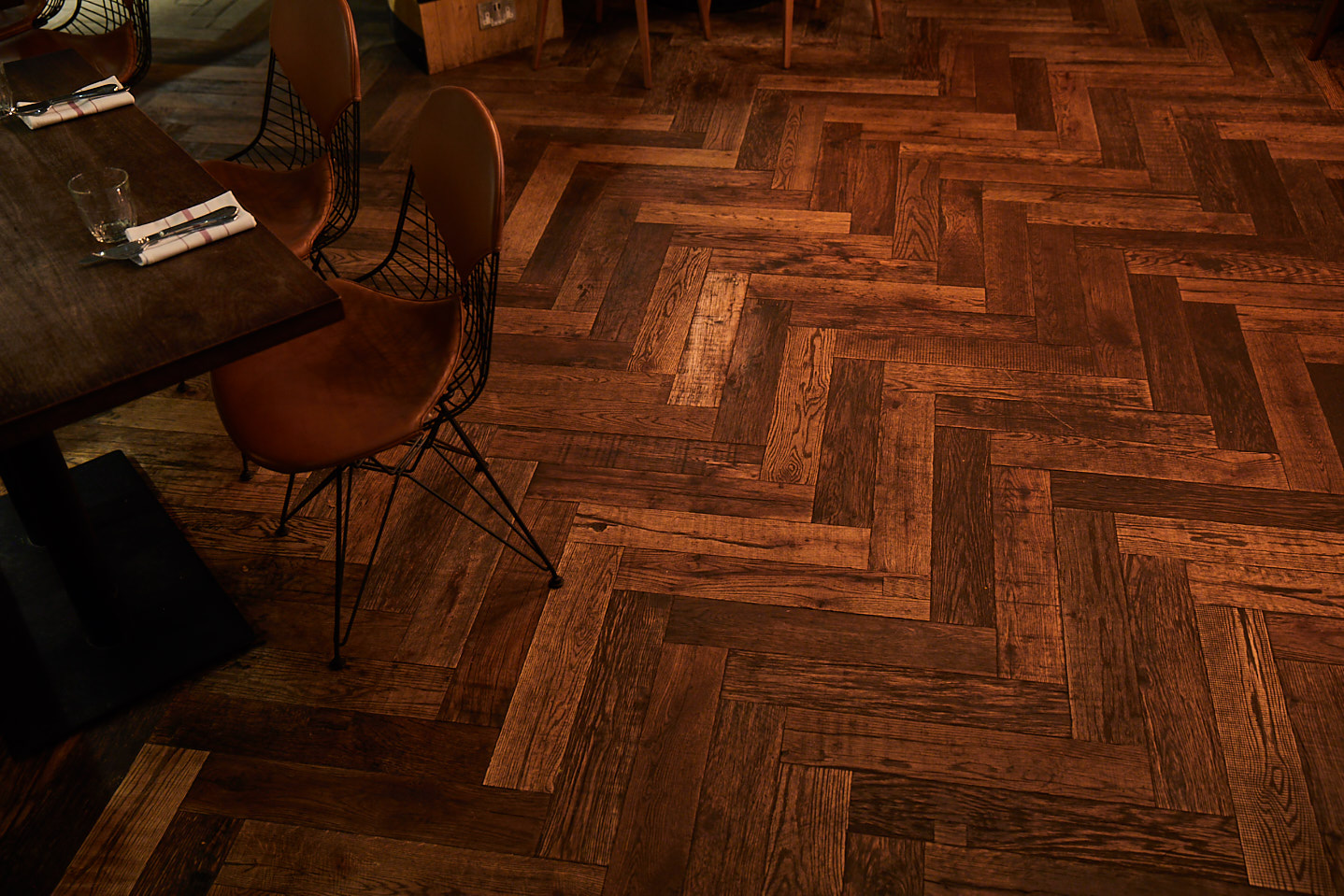 Dining chair sat on reclaimed engineered oak parquet floorboards