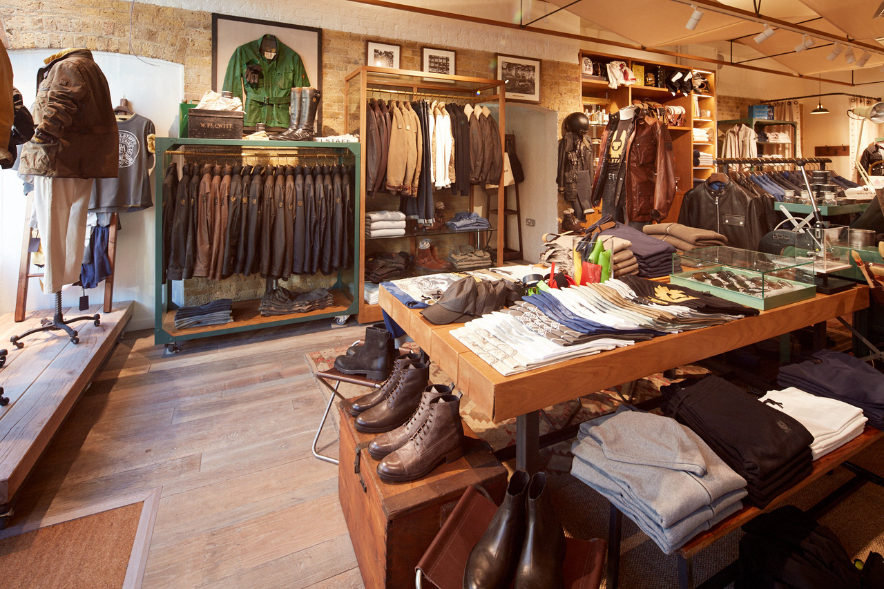 Clothes shop interior with rustic wood floor exposed brick displaying shoes and leather jackets