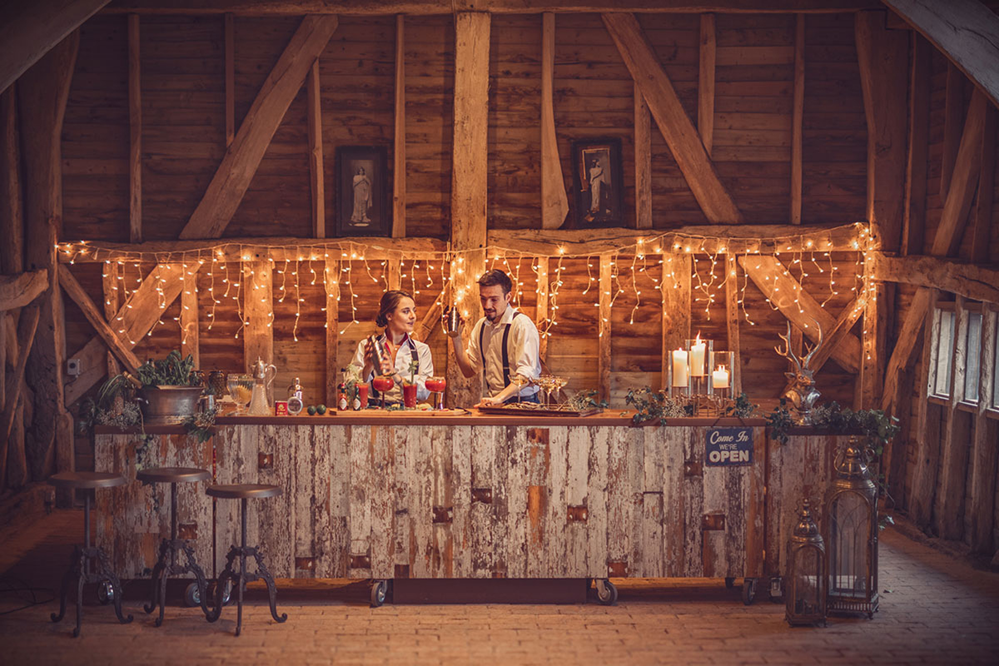 Cocktails been made on long rustic reclaimed bar with copper worktop