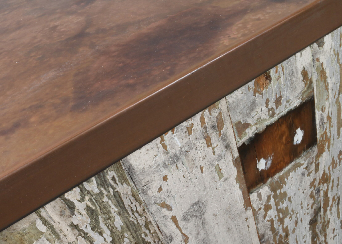 Distressed copper worktop on reclaimed wood cladding