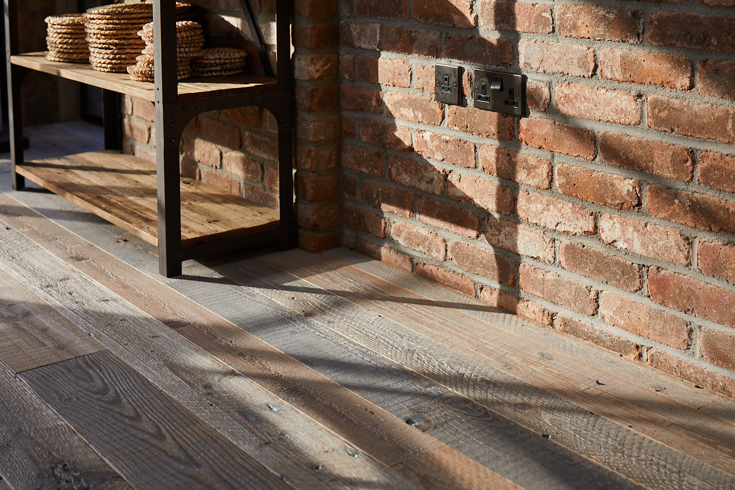 Light shines across spruce flooring and metal industrial shelves