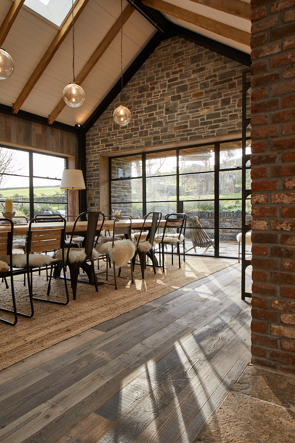 Dining table and chairs sit on reclaimed pine floor boards