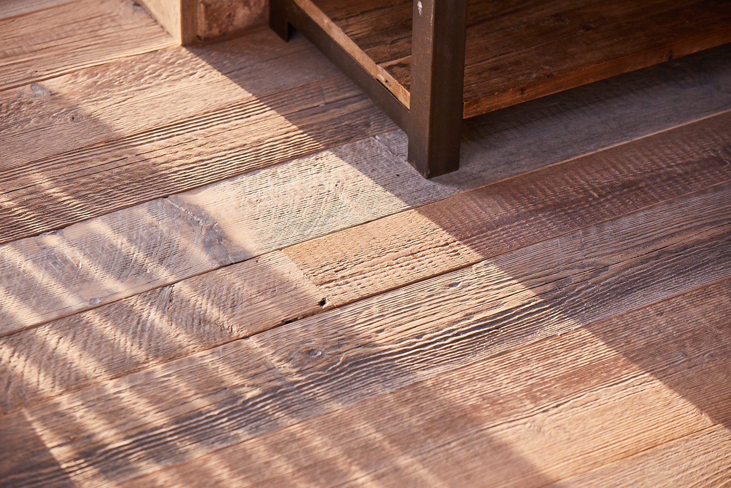 Shadows cast across reclaimed flooring