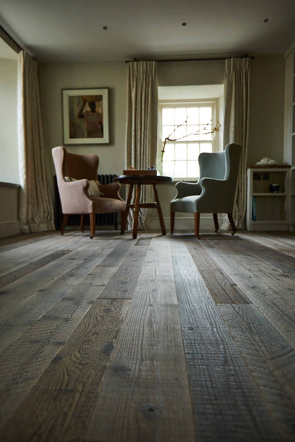 Upholstered occasional chairs sit on reclaimed flooring