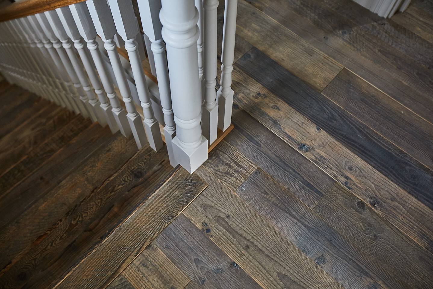 Reclaimed flooring next to painted banister