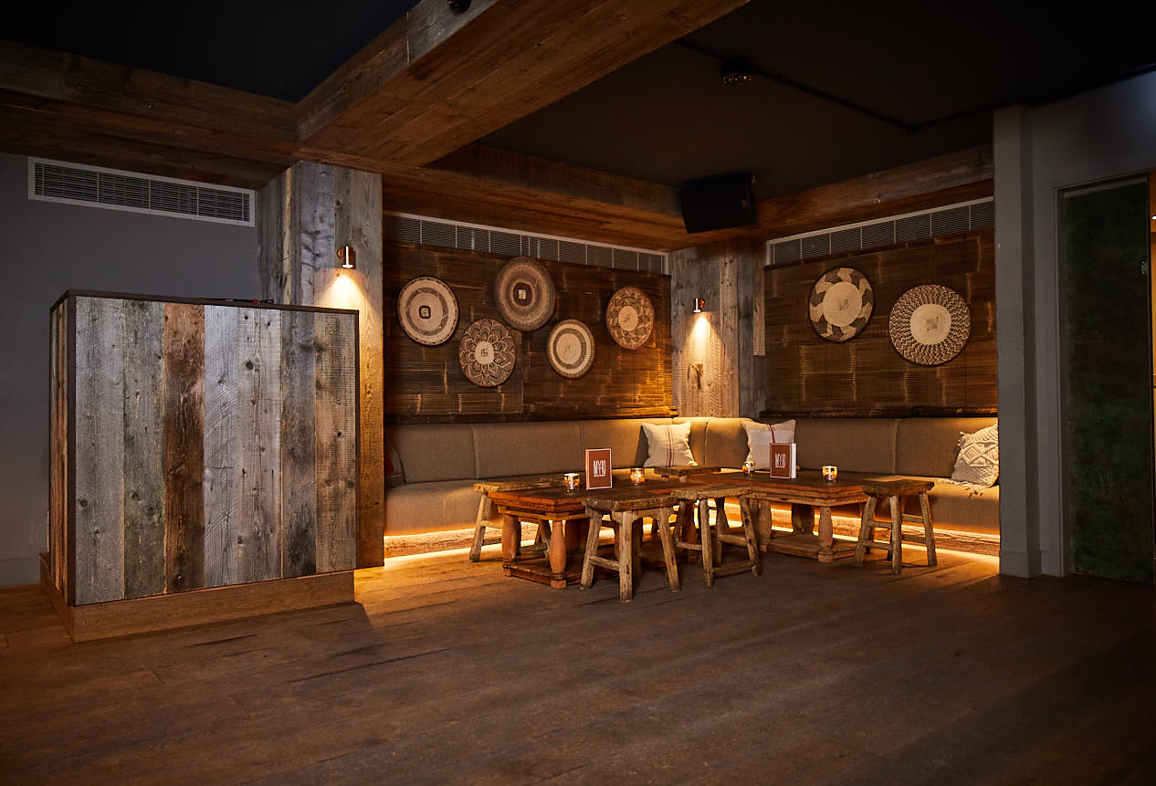 Reclaimed oak bar with large pendant lights and cream sofa