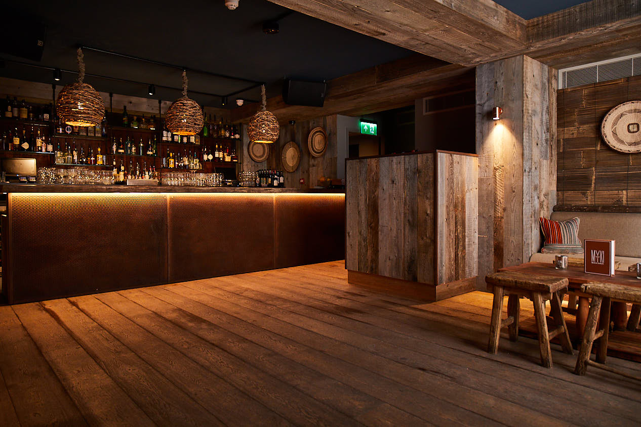 Reclaimed oak bar with large pendant lights hanging above