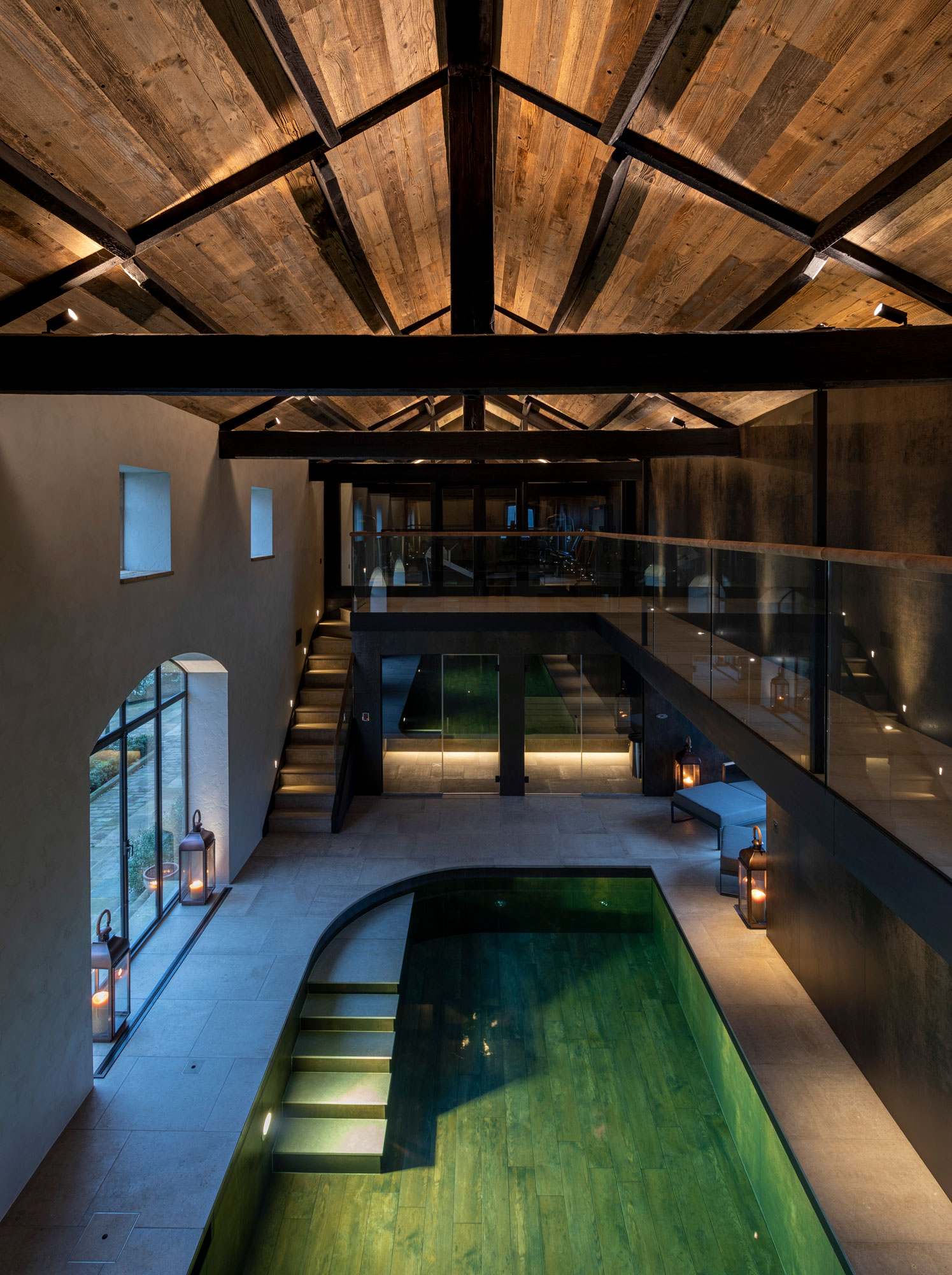 Swimming pool with wooden floor and exposed RSJ beams above