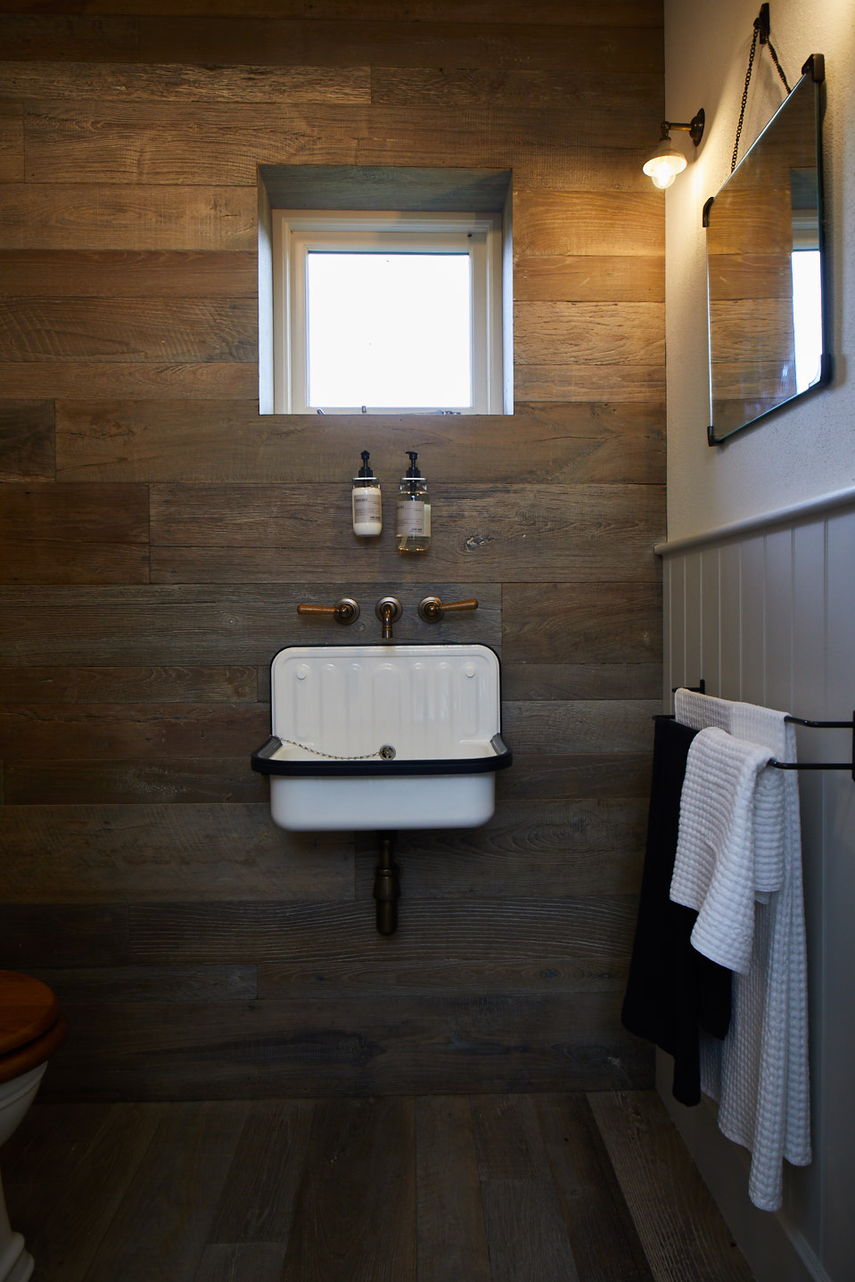 Rustic wood cladding behind sink