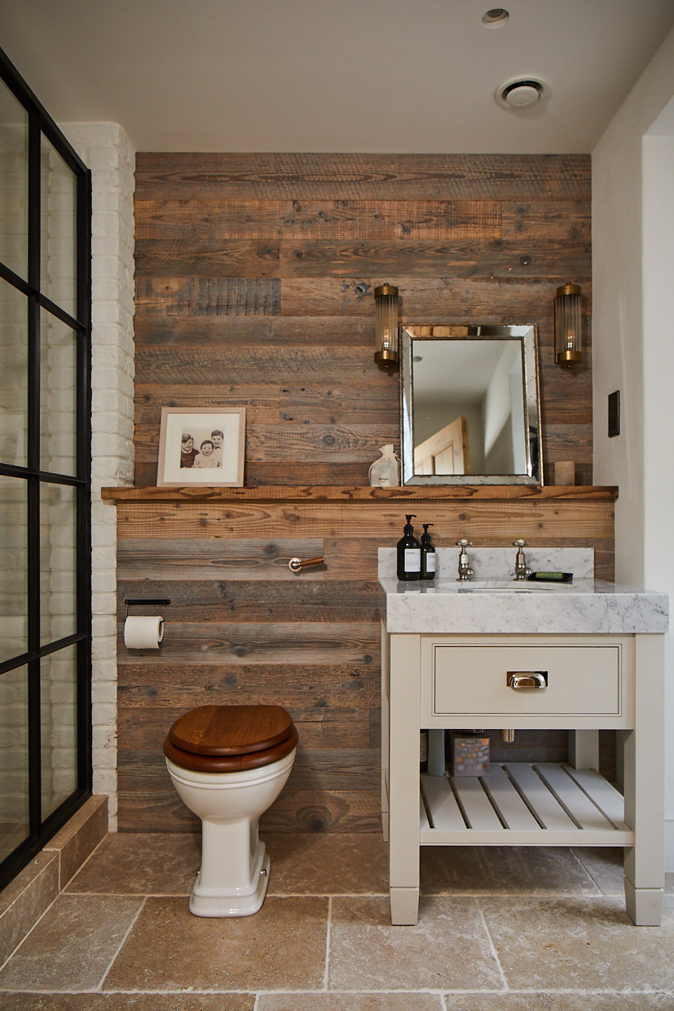 Spruce clad wall in bathroom with painted cream vanity unit