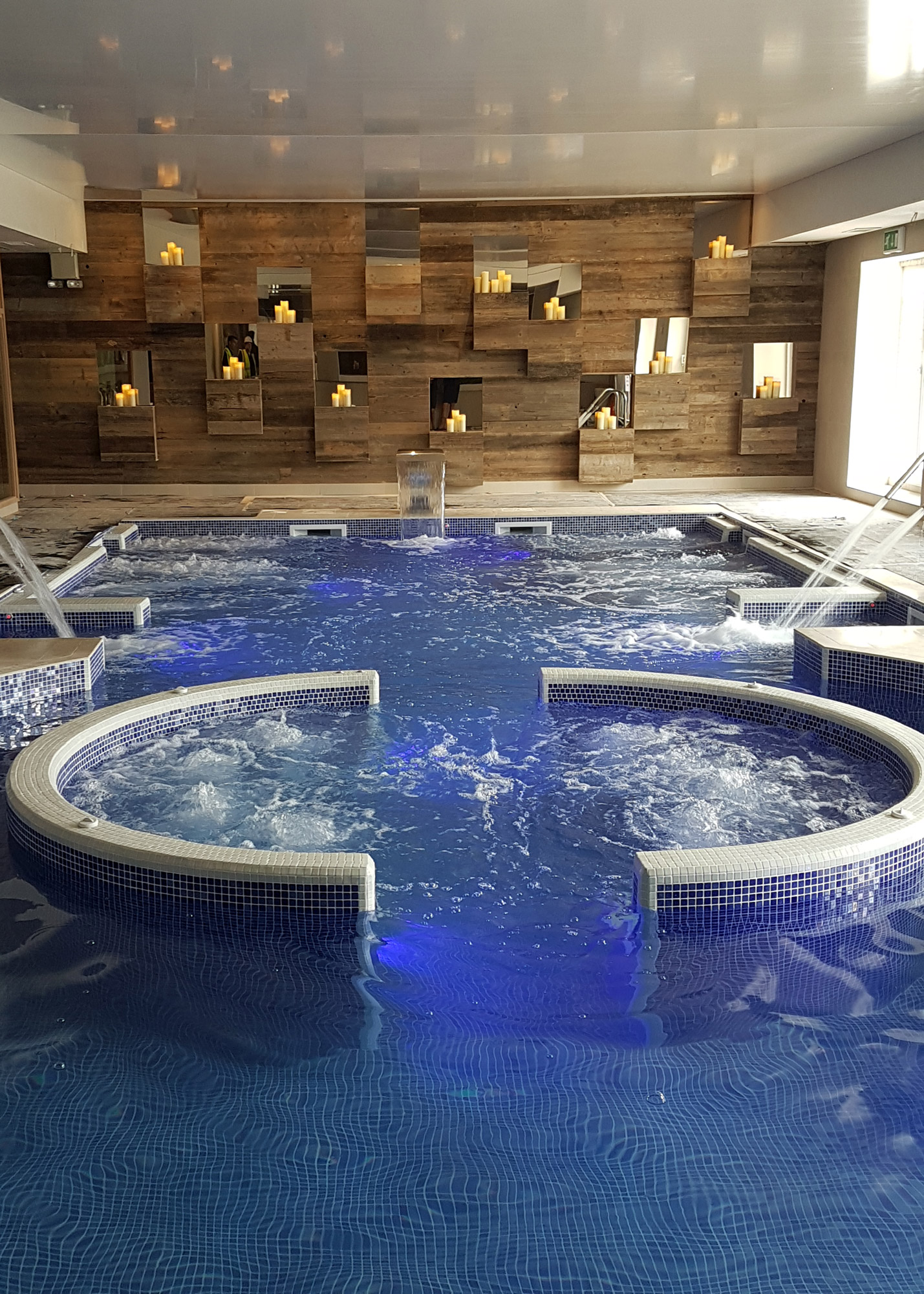 Jacuzzi swimming pool with fully cladded wood wall candle lit