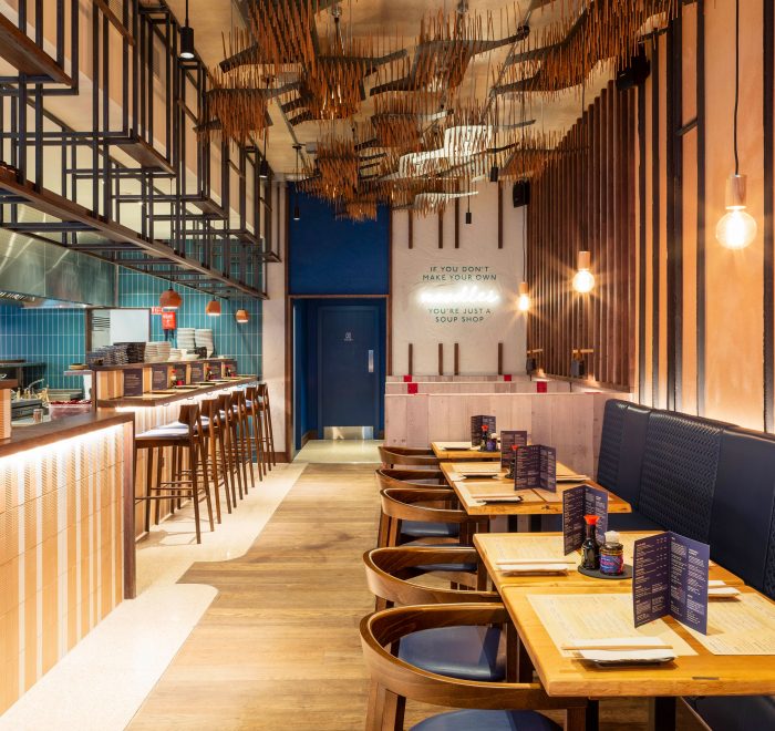 Eatery with blue tiles and walnut and leather blue chairs